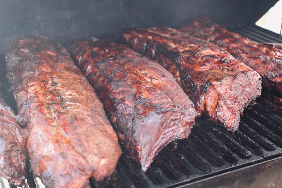 Seasoned pork ribs on the smoker getting that perfect bark